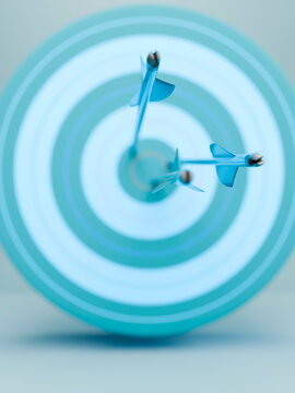 Three blue arrows perfectly hitting the bullseye on a light blue target board