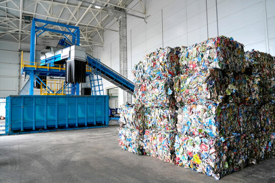 Installation of conveyor for collecting sorting plastic into fractions and collecting them container. Pressed into briquettes, stored in a storage facility atwaste processing and sorting plant.