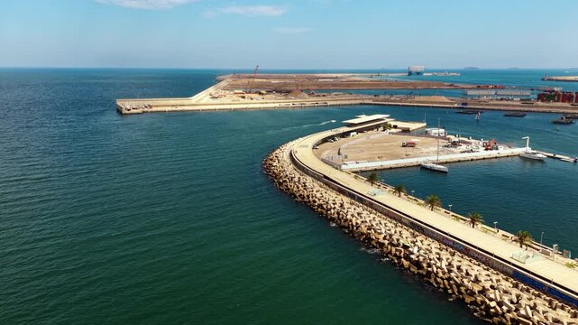 Valencia port aerial view, marina boats and industrial container harbor, Spain. Panoramic wide shot of breakwater, yachts and cranes. High quality 4k footage