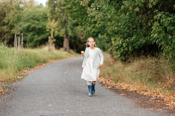 Fototapeta premium Pretty 7 Years Old Girl in Beautiful Dress Posing in Forest Nature