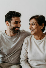 Obraz premium Intergenerational connection and family bonding, happy adult son laughing with his senior mother at home during a quality time conversation