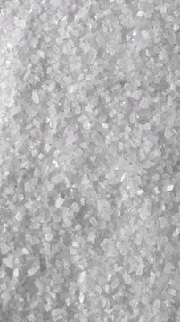 Salt Crystals Slowly Pouring in Macro. Extreme close-up of coarse salt crystals falling slowly and forming a granular cascade.