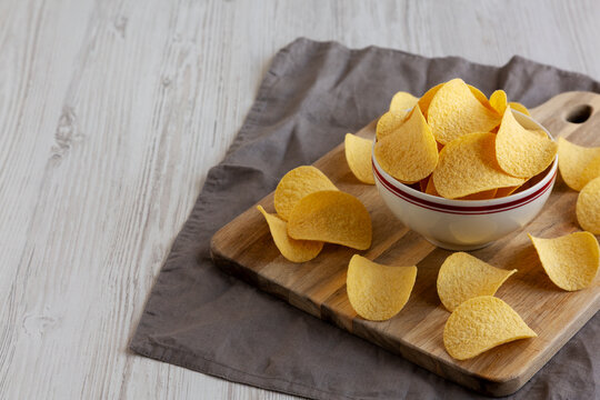 Crispy Cheese and Onion Flavoured Potato Chips in a Bowl, side view. Copy space.