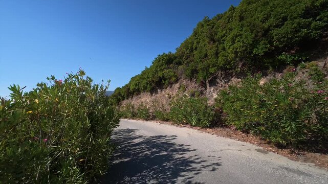 A car drives slowly along a dangerous winding mountain road on the island of Crete, Greece.