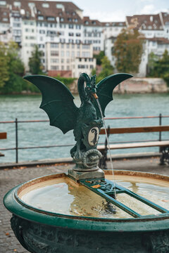 Traditional Basilisk Fountain with Coat of Arms on the Rhine River Waterfront Promenade in Basel Switzerland