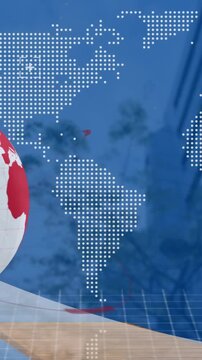 Animation of spinning globe and world map against low angle view of tall buildings