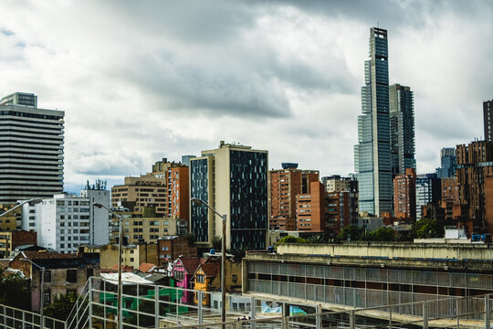 View of the skyline of Bogota, featuring the prominent BD Bacata skyscraper among various modern and historic buildings under a cloudy sky in Bogota, Bogota, Colombia.