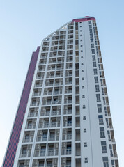 Fototapeta premium Bottom up view gray condominium building with blue sky background