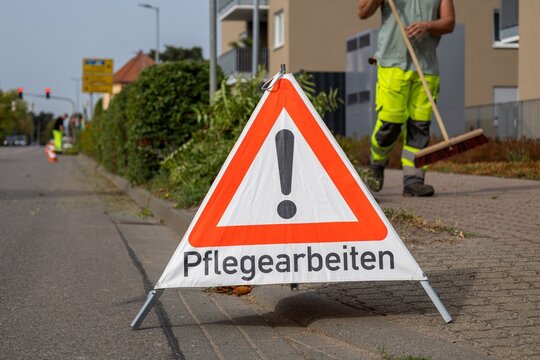 Gr&uuml;npflege: Ein Schild mit der Aufschrift PFLEGEARBEITEN macht Autofahrerinnen und Autofahrer auf die Arbeiten aufmerksam