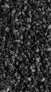 Coal Pieces Shaking. Macro view of black coal fragments trembling and jumping randomly under continuous vibration.