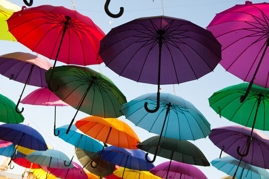 Multicolored umbrellas overlap in a lively outdoor arrangement, decorative festival installation, creative summer background.