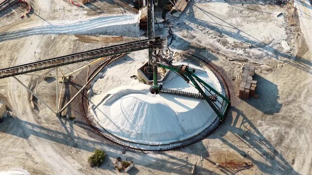 Automated conveyor system handling large quantities of industrial salt inside a processing facility for refining, treatment and further production