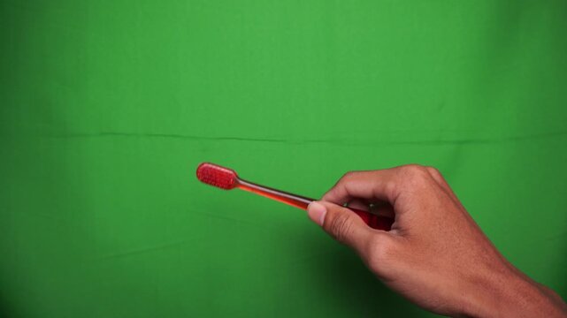 Hand Holding a Matchstick Against a Green Screen Background