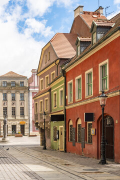 View of colorful historic townhouses with ornate facades and tiled roofs lining a cobblestone street in the Old Market Square of Poznan, Greater Poland Voivod, Poland.