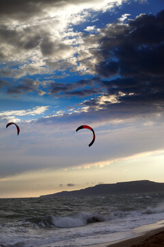 Two silhouette of power kites at sunset sky