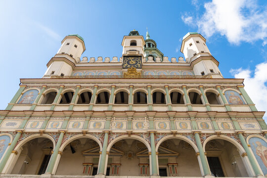 View of the historic Poznan Town Hall featuring its ornate Renaissance facade, clock tower, and elegant arcades under a bright blue sky in Poznan, Greater Poland Voivod, Poland.