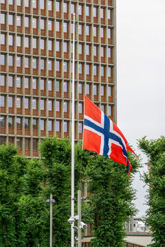 Norway flag flying at half-mast showing national mourning in front of government building