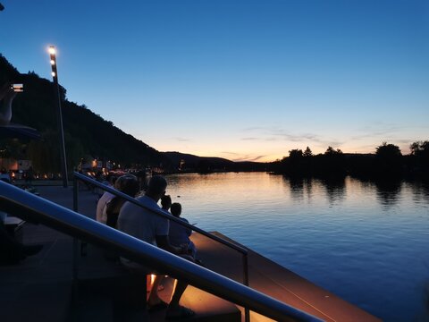 Abendstimmung in Miltenberg am Main am Mainpier mit anonymen Personen die den Sonnenuntergang betrachten