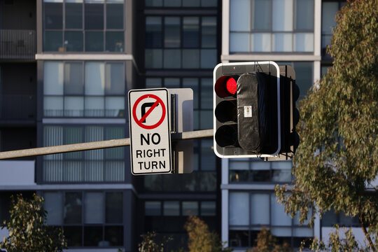 View of suburban traffic lights and no right turn sign with apartments