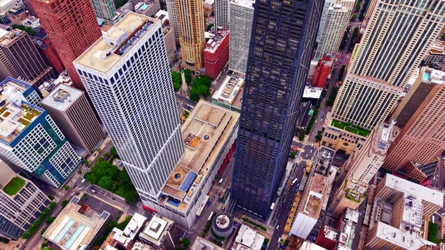 Aerial scale of corporate skyscrapers, Chicago. Perspective of massive highrise towers, rooftop structures, urban streets and green spaces.