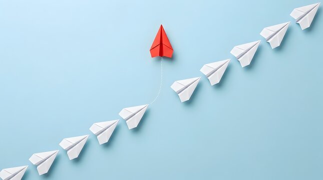 Red paper airplane breaking away from white planes on blue background for leadership concept