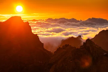 Fotobehang Bruin Majestic golden sunrise illuminating a dramatic sea of clouds and rugged volcanic peaks at Pico do Arieiro scenic summit landscape in Madeira, Portugal.  © Dragoș Asaftei
