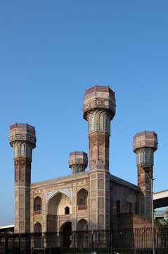 View of the historic Chauburji monument featuring its iconic four minarets, intricate tile work, and arched gateways under a clear blue sky in Lahore, Punjab, Pakistan.