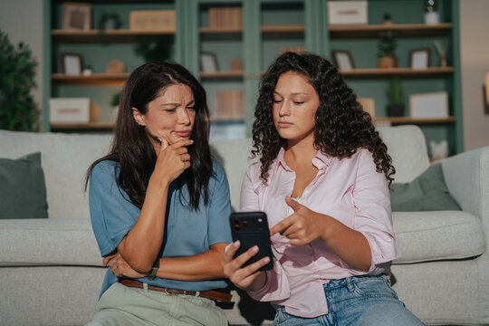 Mother and daughter bonding over smartphone at home