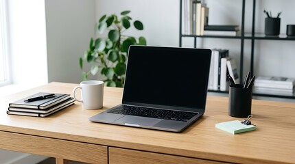 Fototapeta premium A modern home office desk featuring a laptop computer with a blank screen and office supplies on wooden surface