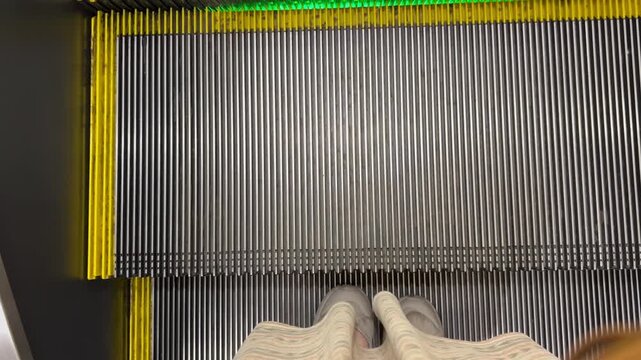 エスカレーターに乗る女性の足元