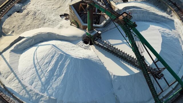 Automated conveyor system handling large quantities of industrial salt inside a processing facility for refining, treatment and further production
