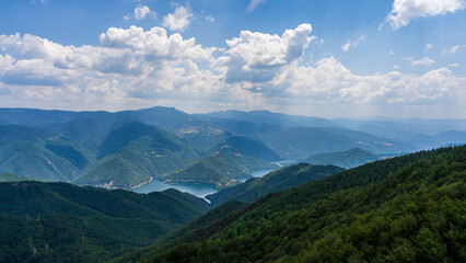 Fototapeta premium Forest mountains and lake under summer clouds