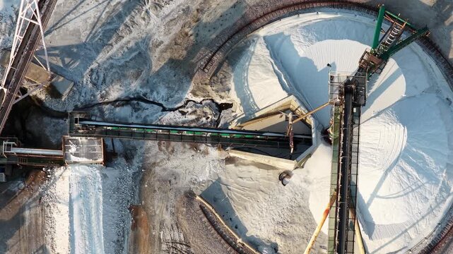 Automated conveyor system handling large quantities of industrial salt inside a processing facility for refining, treatment and further production