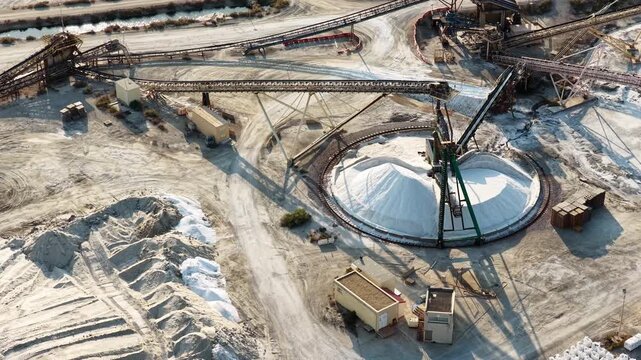 Automated conveyor system handling large quantities of industrial salt inside a processing facility for refining, treatment and further production