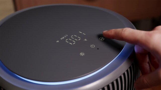 Man pressing touch panel on smart air purifier display