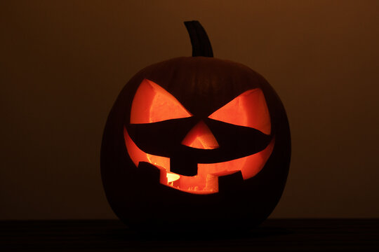 Halloween pumpkins and burning candles on wooden background
