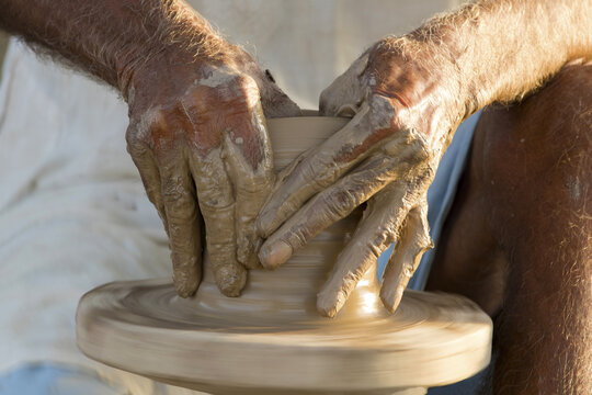 View of a potter shaping a clay pot on a spinning wheel in Multan City, Punjab, Pakistan.