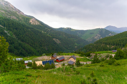 View of small wooden cabins nestled in the lush green mountains of the Accursed Mountains range near Decan, Kosovo.