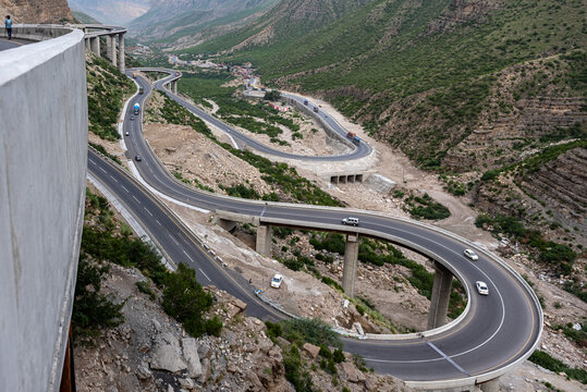 View of the winding Fort Munro Road with its hairpin turns and concrete bridges cutting through the rugged mountain landscape in Fort Monroe, Punjab, Pakistan.