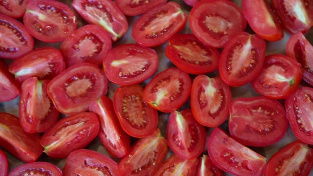 Red ripe halfed tomatoes as background, top view. A lot of chopped tomatoes, ready to cook healthy food.