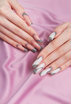 Woman showing trendy gray pink nail art manicure