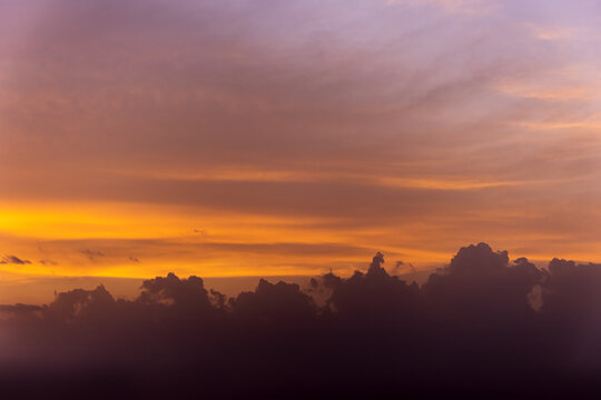 View of a vibrant sunset with orange and purple clouds over the horizon in Jahanian, Punjab, Pakistan.