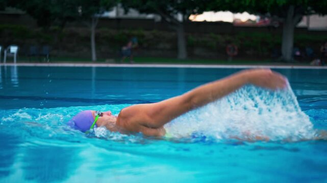 Professional female athlete swimming the backstroke in an outdoor pool, practicing for competition and showcasing her endurance, power, and precise swimming technique