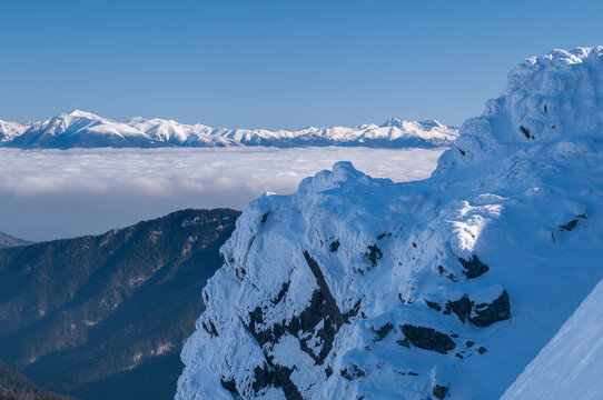 View of the snow-covered peak of Dumbier rising above a sea of clouds in the Low Tatras mountains under a clear blue sky, Nizke Tatry, Zilina Region, Slovakia.