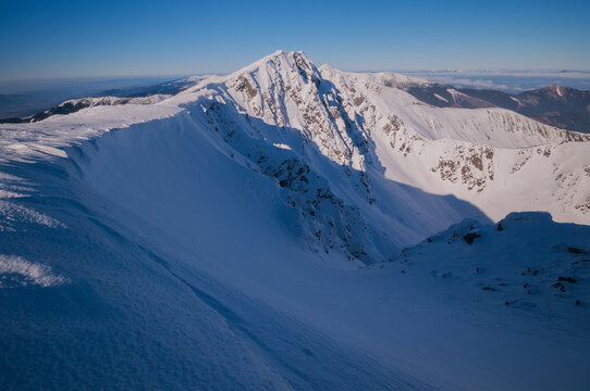 View of the snow-covered peak of Dumbier mountain under a clear blue sky in Nizke Tatry, Zilina Region, Slovakia.