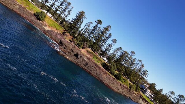 Arial Spiral Barrel Roll towards coast line, pine trees and blue ocean. For advertising, blog content, influencer media. 
