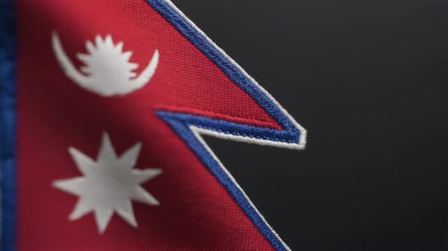 Extreme macro footage of a single Nepal national flag, close-up on the white crescent moon emblem