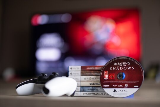 BRECHT, BELGIUM &ndash; August 28, 2026: Closeup portrait of a stack of PS5 games, a controller, a physical game disc and a blurred playstation home screen in the background.