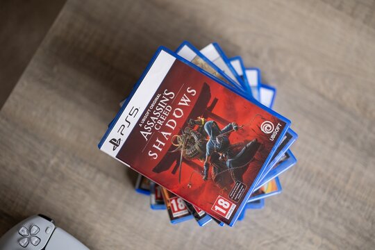 BRECHT, BELGIUM &ndash; August 28, 2026: Portrait of a stack of PS5 playstation games with a playstation controller lying next of it on a table, highlighting physical gaming media.