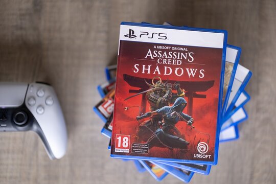 BRECHT, BELGIUM &ndash; August 28, 2026: Macro portrait of a stack of PS5 playstation games with a playstation controller lying next of it on a table, highlighting physical gaming media.